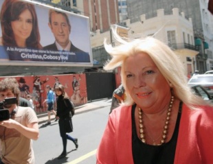 Elisa Carrió pasa por diante dos carteis electorais do Frente para la Victoria